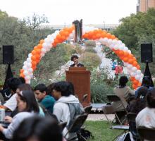 student speaking in front of other students at an event