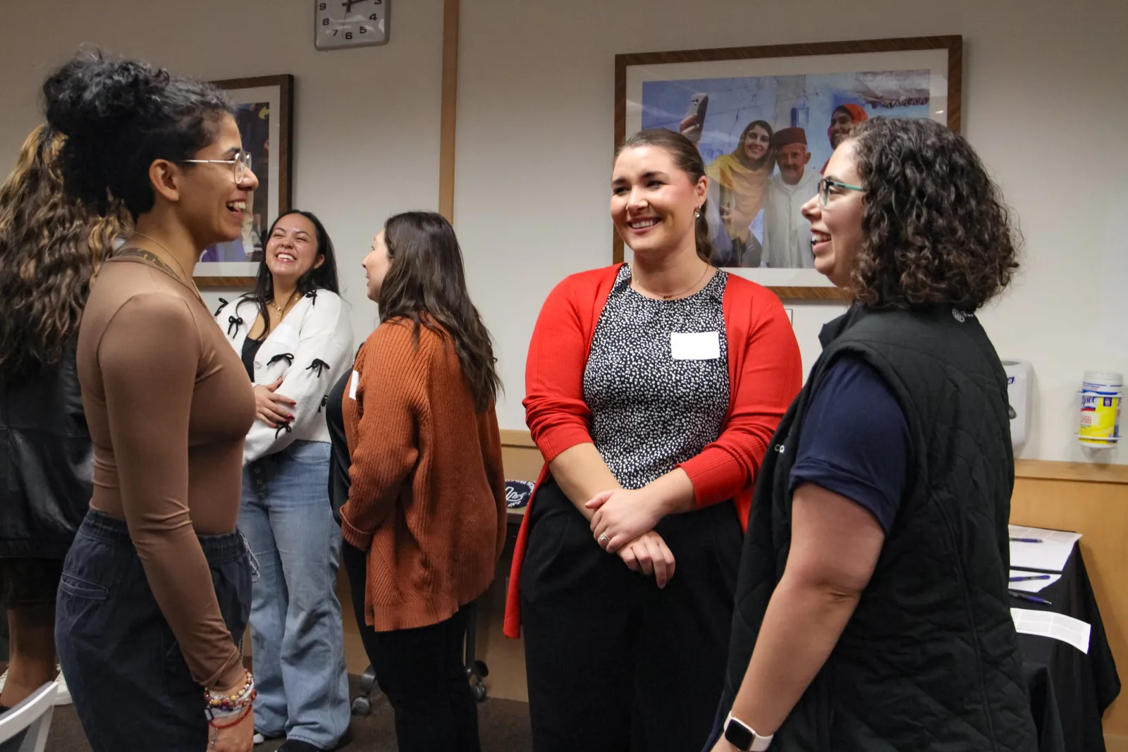 two mentors smiling at a student who is talking to them