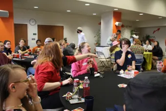 students playing Uno, one student is pointing to another smiling and laughing