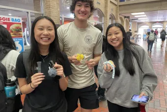 Three students pose with their fidgets at Fidget Friday.
