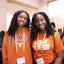 two students smiling at camera with UT Austin shirts