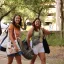 students doing hookem horns walking into orientation with pillows and bags