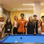 students standing together near a pool table