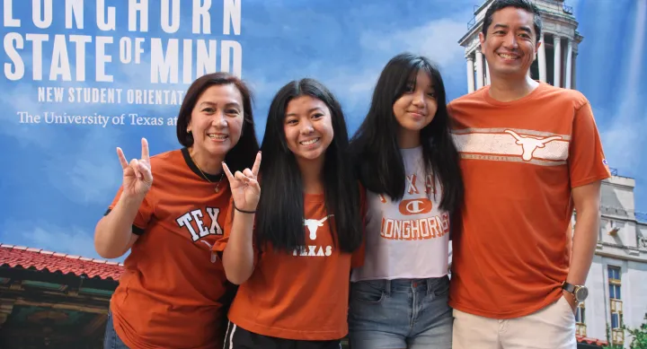 Family poses with the LSOM backdrop at orientation