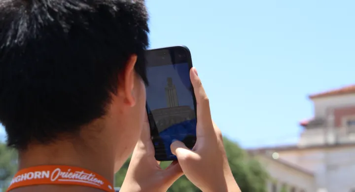 Student at Longhorn Orientation taking a photo of the iconic UT Tower