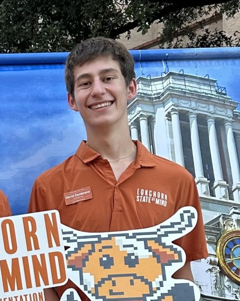 student smiling with a photobackdrop of the tower in the background