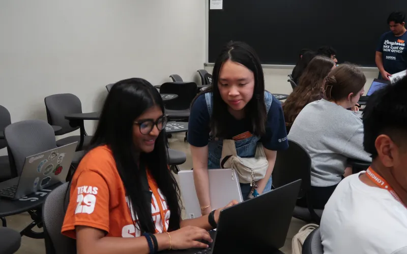 An orientation advisor offers course registration assistance to a student at Longhorn Orientation
